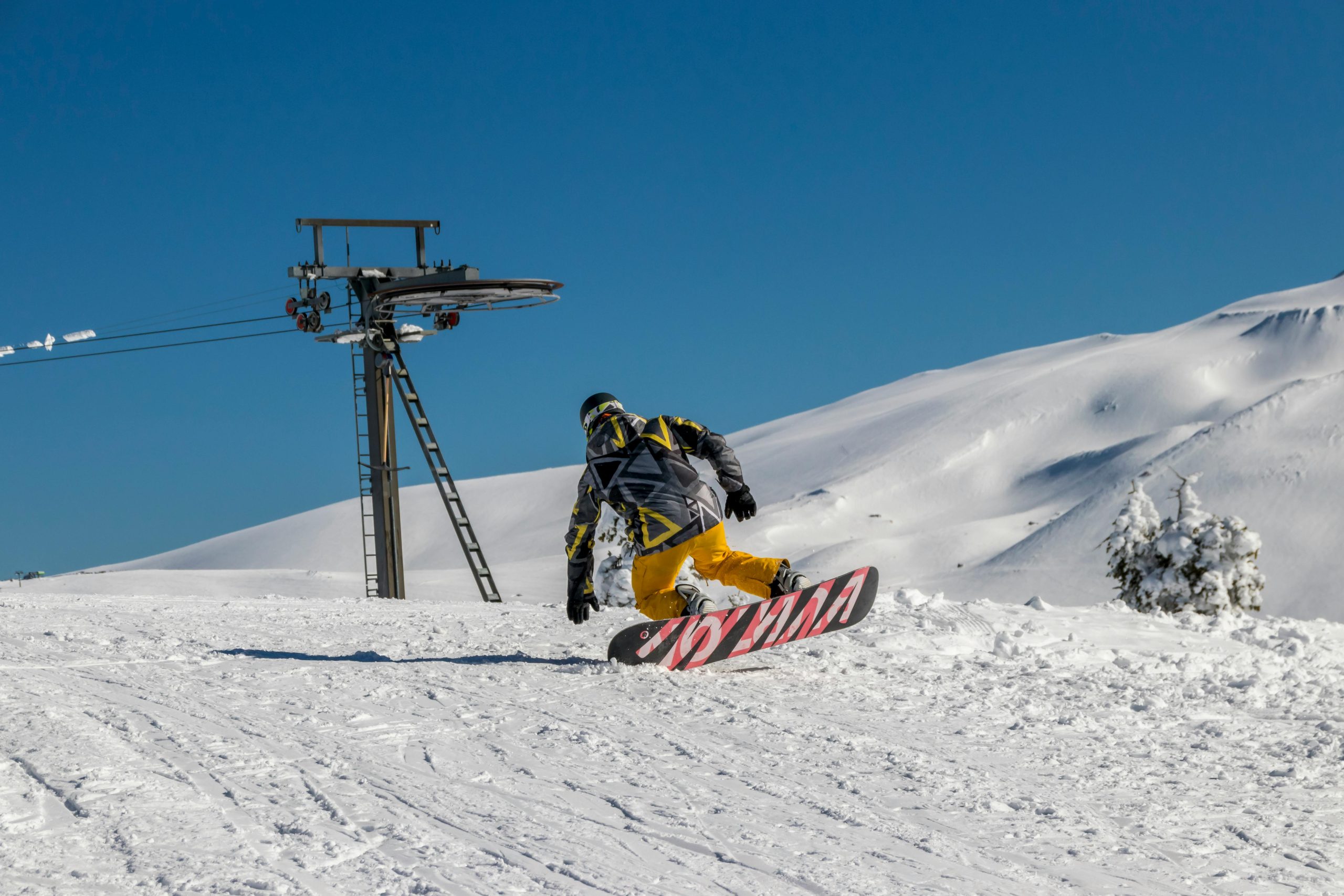 Snowboarder étudiant dévalant une piste de ski pendant un voyage BDE à la montagne